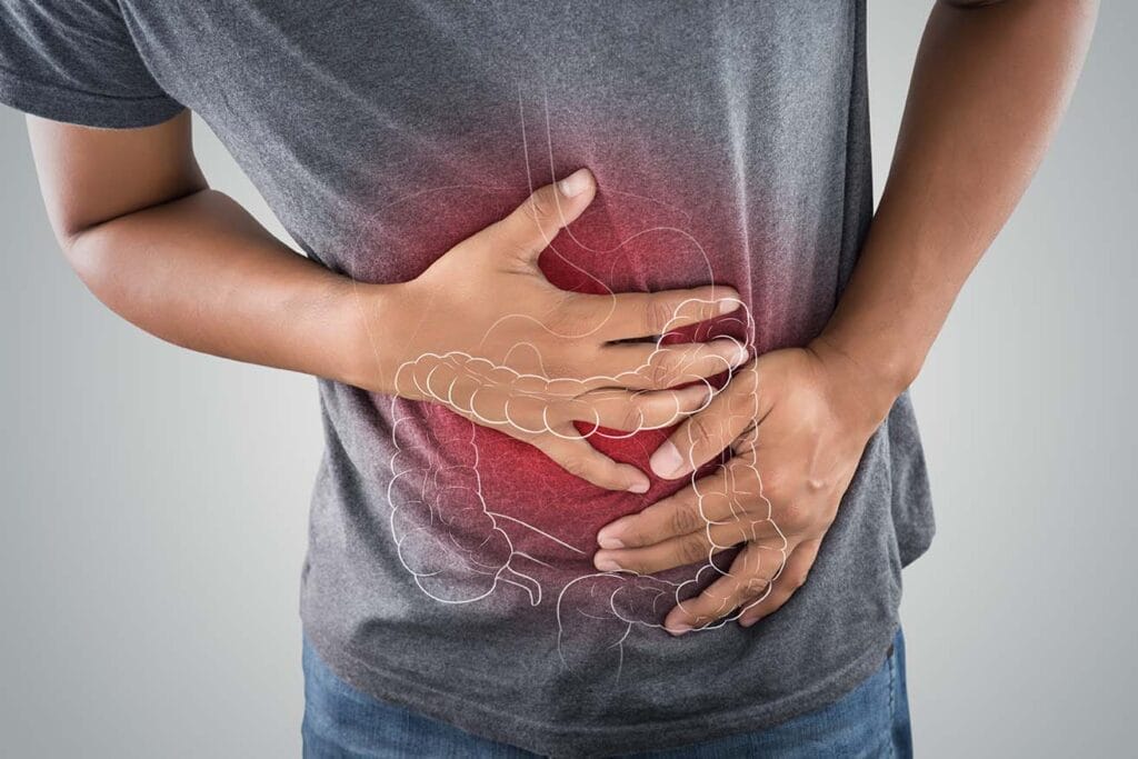 The photo of large intestine is on the man's body against gray background, People With Stomach ache problem concept